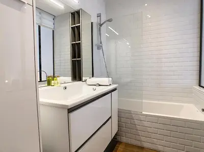 a white bathroom with a sink and a bath tub at Nestor&Jeeves - REINE MARIE TERRASSE - Central - Very close sea - Top floor in Nice