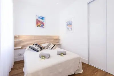 a white bedroom with a bed with two pillows at MY CASA - SPITALIERI- Sunny Terrace with view in Nice