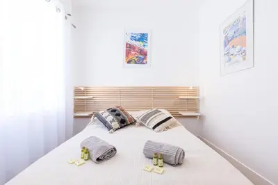a white bedroom with a bed with two pillows at MY CASA - SPITALIERI- Sunny Terrace with view in Nice