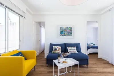 a living room with a blue couch and yellow chairs at MY CASA - SPITALIERI- Sunny Terrace with view in Nice