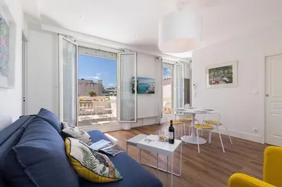 a living room with a blue couch and a table at MY CASA - SPITALIERI- Sunny Terrace with view in Nice