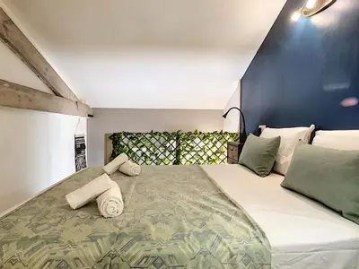 a bedroom with a large bed with pillows on it at Nestor&Jeeves - SECRET BEACH DUPLEX - Very close sea - Atypical in Nice