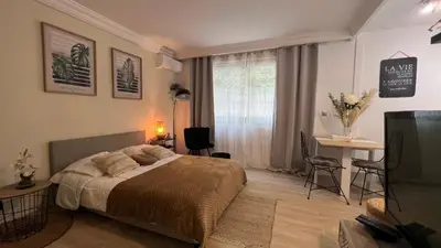 a bedroom with a bed and a desk and a window at LE MIRAMAR Nice - Clim, Parking, Wifi et piscine in Nice