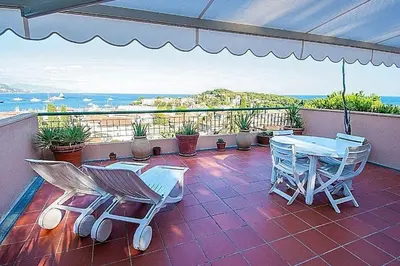 a patio with a table and chairs on a balcony at AMAZING SEA VIEW APARTMENT with Private Close Parking in Saint-Jean-Cap-Ferrat