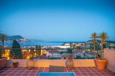 a balcony with palm trees and a view of the ocean at AMAZING SEA VIEW APARTMENT with Private Close Parking in Saint-Jean-Cap-Ferrat