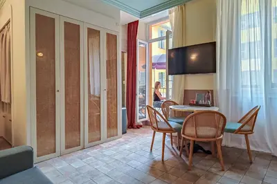 a dining room with a table and chairs and a television at Hotel Aparthotel AMMI Vieux Nice in Nice