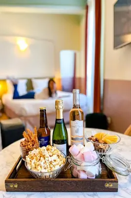 a tray with two bottles of wine and snacks on a table at Hotel Aparthotel AMMI Vieux Nice in Nice