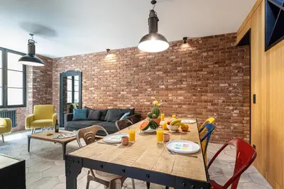 a dining room with a table and a brick wall at FEEL HOME - BUNICO in Nice