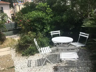 three chairs and a table and a table and chairs at Cozy house with parking and garden in Nice