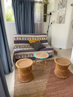 a living room with a couch and two tables at Cozy house with parking and garden in Nice