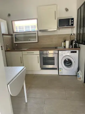 a kitchen with a washing machine and a washer at Cozy house with parking and garden in Nice