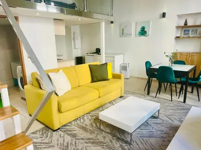 a living room with a yellow couch and a table at Alexandre Mari old town few meters to the beach in Nice