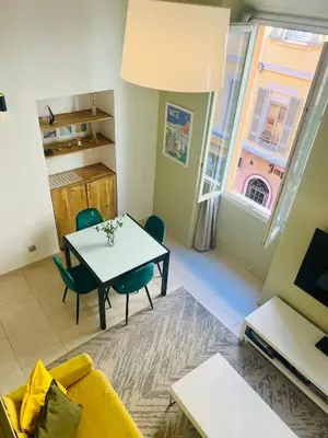 a living room with a table and chairs and a window at Alexandre Mari old town few meters to the beach in Nice