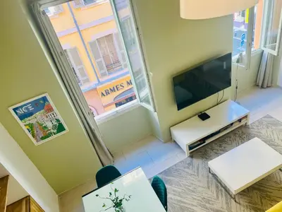 a living room with a flat screen tv and a window at Alexandre Mari old town few meters to the beach in Nice