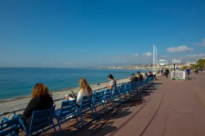a group of people sitting in chairs on the beach at Le Magenta - Happy Rentals in Nice