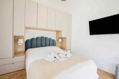 a bedroom with a large bed with a blue headboard at Le Magenta - Happy Rentals in Nice