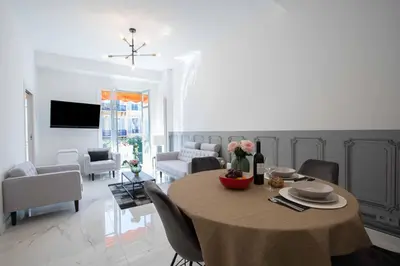 a dining room with a table and a living room at Le Magenta - Happy Rentals in Nice