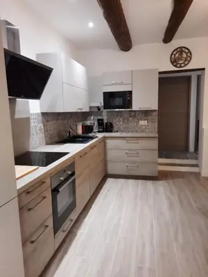 a kitchen with white appliances and a wooden floor at Beautiful Old Town flat, near the beach in Nice