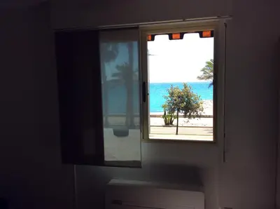 a window with a view of the beach at Poseidon in Cagnes-sur-Mer