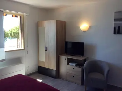a bedroom with a bed and a tv and a chair at Poseidon in Cagnes-sur-Mer