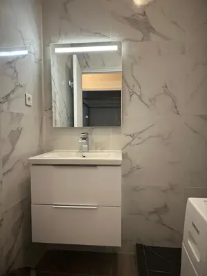 a bathroom with a white sink and a mirror at Grand Studio avec Coin Nuit et Parking in Saint-Laurent-du-Var