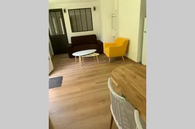 a living room with a table and a couch at Appartement neuf 4-6 personnes en bord de Mer in Nice