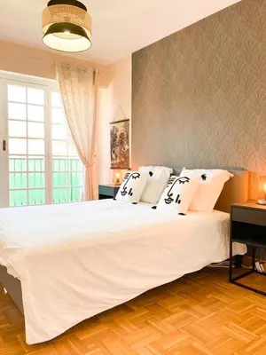 a bedroom with a large white bed and a window at Résidence Le Castille in Nice