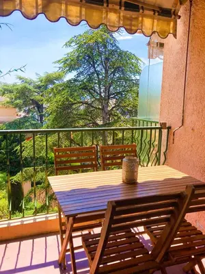 a wooden table and bench on a balcony at Résidence Le Castille in Nice