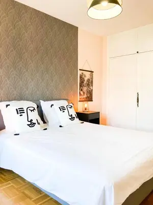 a bedroom with a large bed with white sheets at Résidence Le Castille in Nice