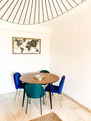 a dining room with a table and blue chairs at Résidence Le Castille in Nice