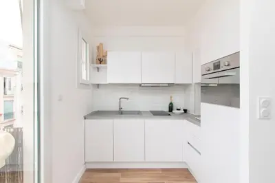 a white kitchen with white cabinets and a sink at Maison Bianchi - Herold in Nice