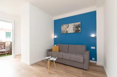 a living room with a couch and a blue wall at Maison Bianchi - Herold in Nice
