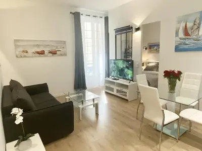 a living room with a couch and a table and a tv at Central Modern Flat Lamartine in Nice