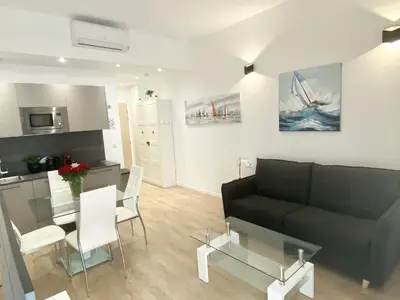 a living room with a black couch and a table at Central Modern Flat Lamartine in Nice