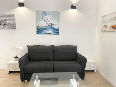 a living room with a black couch and a painting at Central Modern Flat Lamartine in Nice