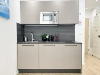 a kitchen with white cabinets and a microwave at Central Modern Flat Lamartine in Nice