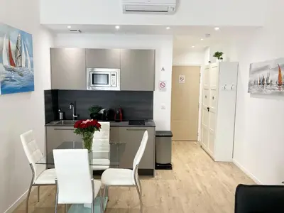 a kitchen and dining room with a glass table and white chairs at Central Modern Flat Lamartine in Nice
