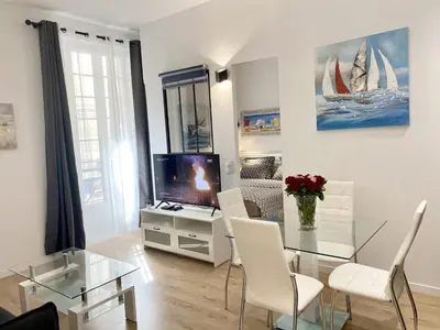 a living room with a glass table and a tv at Central Modern Flat Lamartine in Nice