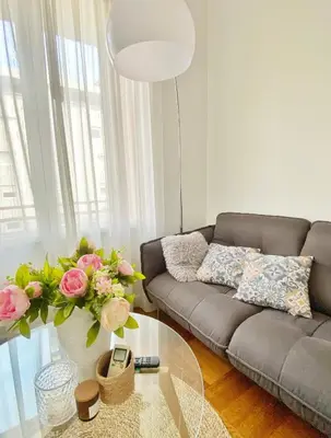 a living room with a couch and a glass table at Le Philanthrope - Balcon Wifi Climatisation in Nice