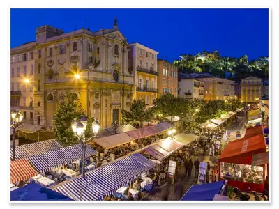 a city street with many tables and buildings at night at Le Philanthrope - Balcon Wifi Climatisation in Nice