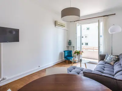 a living room with a blue couch and a table at Le Philanthrope - Balcon Wifi Climatisation in Nice