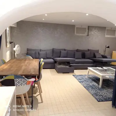 a living room with a couch and a table at Charming and Modern Cave in the Heart of the Port in Nice