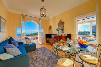 a living room with a blue couch and a table at Villa MonTLilin - Happy Rentals in Villefranche-sur-Mer