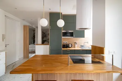 a kitchen with green cabinets and a wooden counter top at La Maioneta Vieux-Nice in Nice