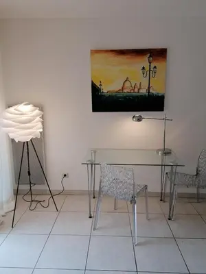 a table and chairs in a room with a painting on the wall at Studio neuf 25 m2, terrasse 35 m2 proche port Nice, Centre ville in Nice