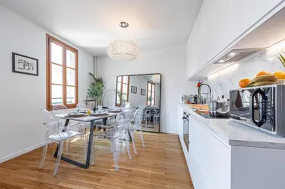 a kitchen and dining room with a table and chairs at FEEL HOME - ALPHONSE KARR in Nice