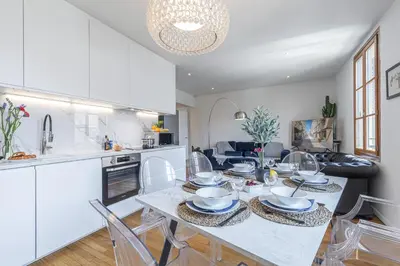 a kitchen and living room with a table and chairs at FEEL HOME - ALPHONSE KARR in Nice