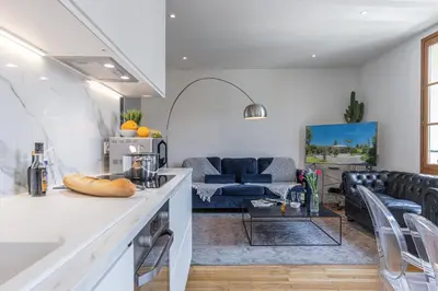 a kitchen and living room with a blue couch at FEEL HOME - ALPHONSE KARR in Nice