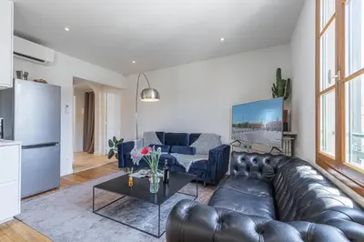 a living room with a leather couch and a table at FEEL HOME - ALPHONSE KARR in Nice
