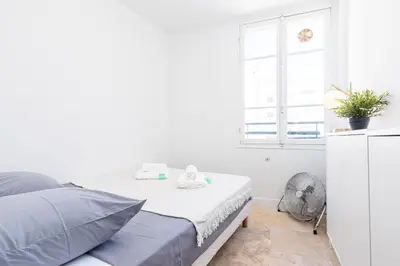 a white bedroom with a bed and a window at FEEL HOME - ALPHONSE KARR in Nice